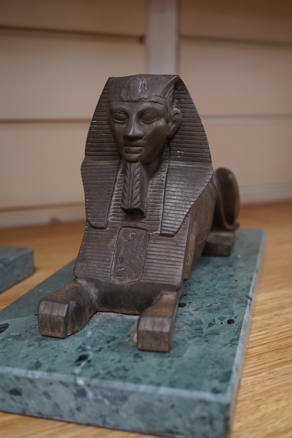 A pair of cast iron models of Sphinxes, raised on green serpentine marble bases, 32cm long. Condition - fair, both detached from bases